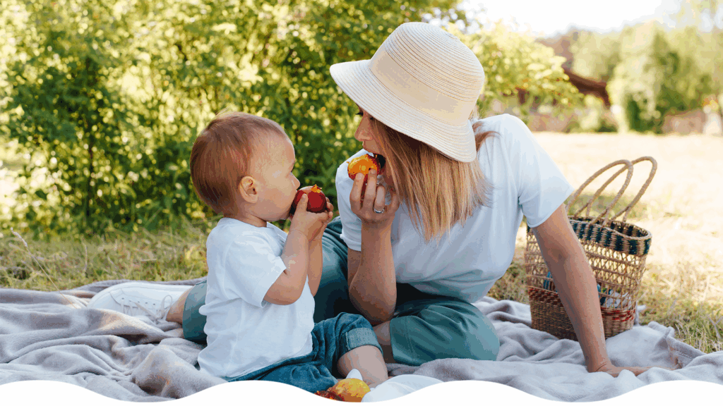 Bebé y mamá consumen fruta durante un día caluroso de verano
