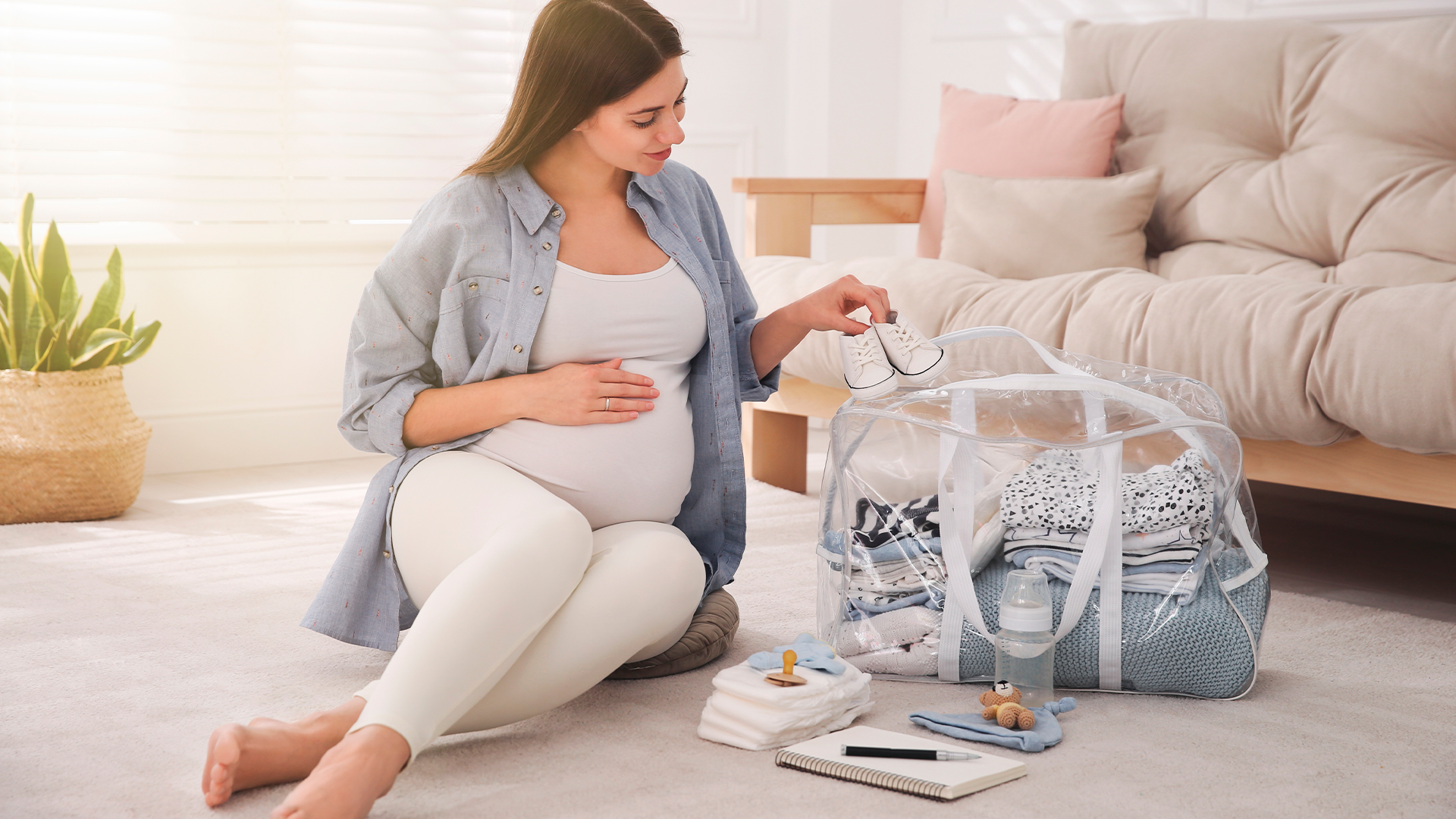 Mujer embarazada preparando su maleta para el hospital.