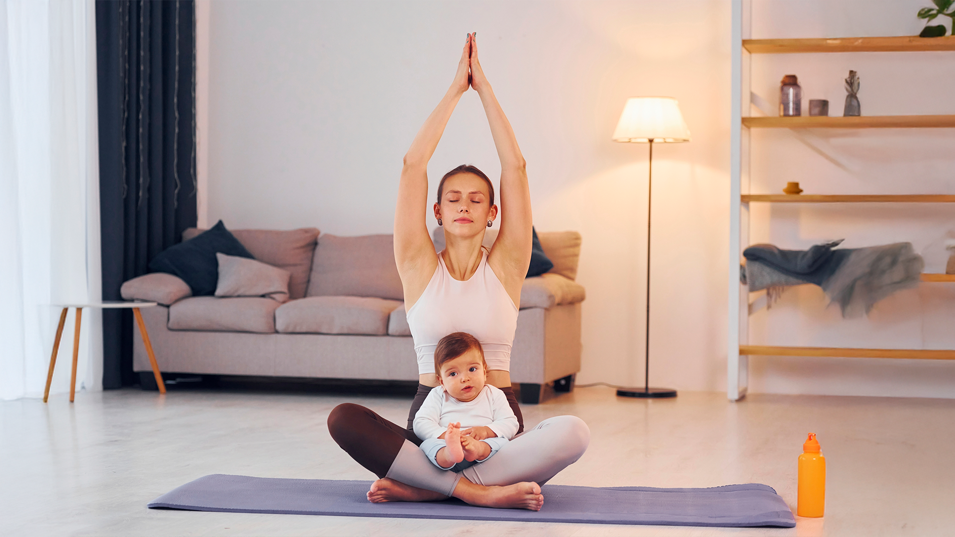 Mamá realizando yoga acompañada por su bebé