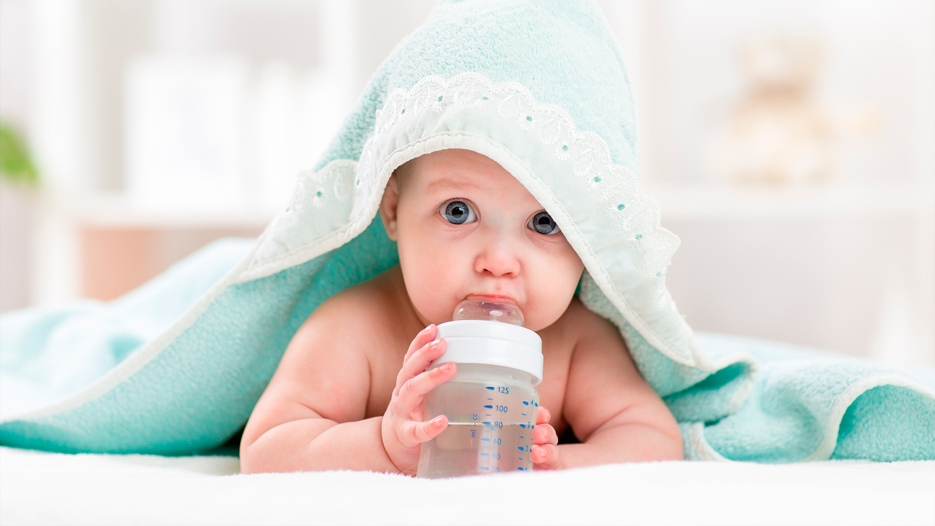 Bebé bebiendo agua de una botella, parte de la rutina para mantenerse hidratado en la etapa de alimentación complementaria