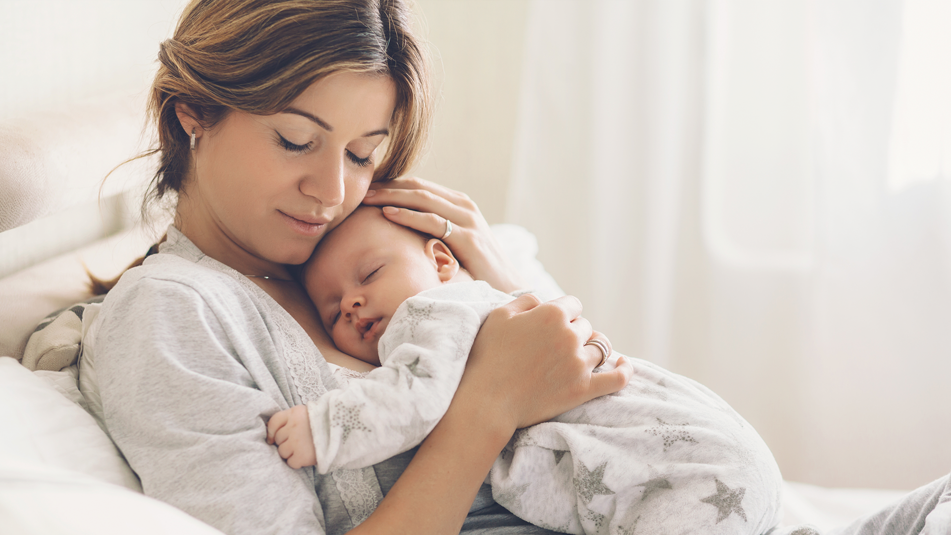Mamá abrazando a su bebé antes de dormir, en casa