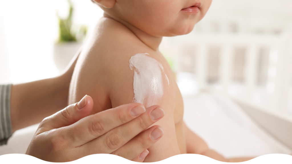 Mamá aplicando productos de cuidado de piel sensible a su bebé en verano