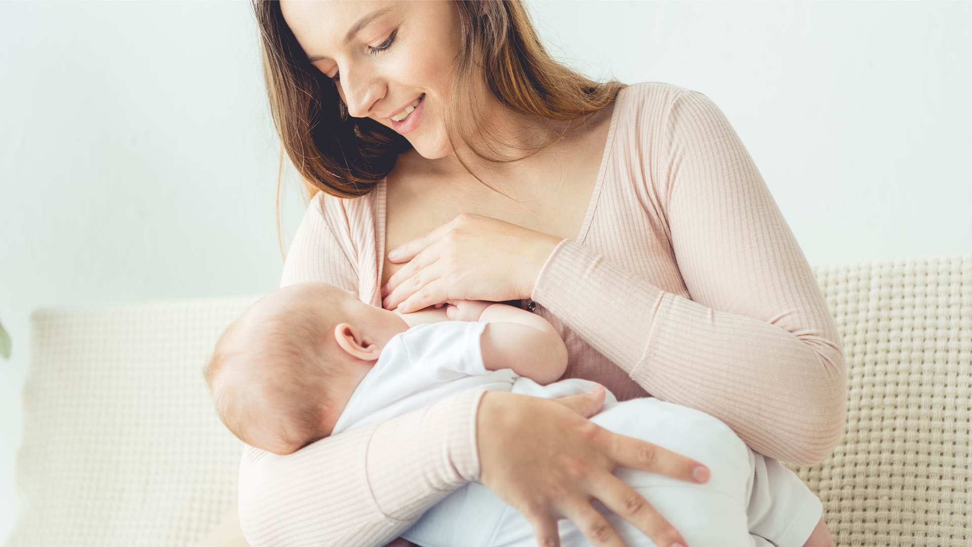 Mamá practicando la lactancia materna con su bebé recién nacido en casa